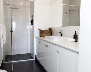 A modern bathroom with a glass shower enclosure, a white sink, and a large mirror. - SELLICKS BEACHSIDE RETREAT unwind by the sea (Sellicks Beach)