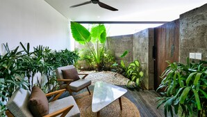 Et moderne interiør med en ventilator i loftet, et siddeområde med et bord og forskellige planter.