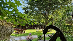 Un jardin avec un banc, une statue et une structure métallique.