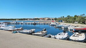 A marina with various boats docked, a clear blue sky, and buildings in the background. - Cosy apartment for 6 guests with A/C, WIFI, TV, terrace and pets allowed (Zadar)