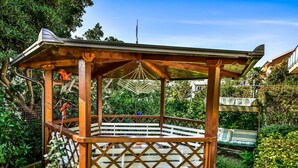 A wooden gazebo with a lattice floor and a striped canopy. - Cosy apartment for 6 guests with A/C, WIFI, TV, terrace and pets allowed (Zadar)