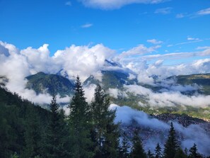 A mountainous landscape with dense forests and a town nestled among the hills. - Holiday Apartment 'Burgbergblick' with Mountain View, Balcony and Wi-Fi (Mittenwald)