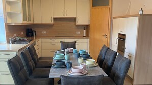 Una cocina moderna con comedor, que incluye una isla central, armarios empotrados y una cafetera.