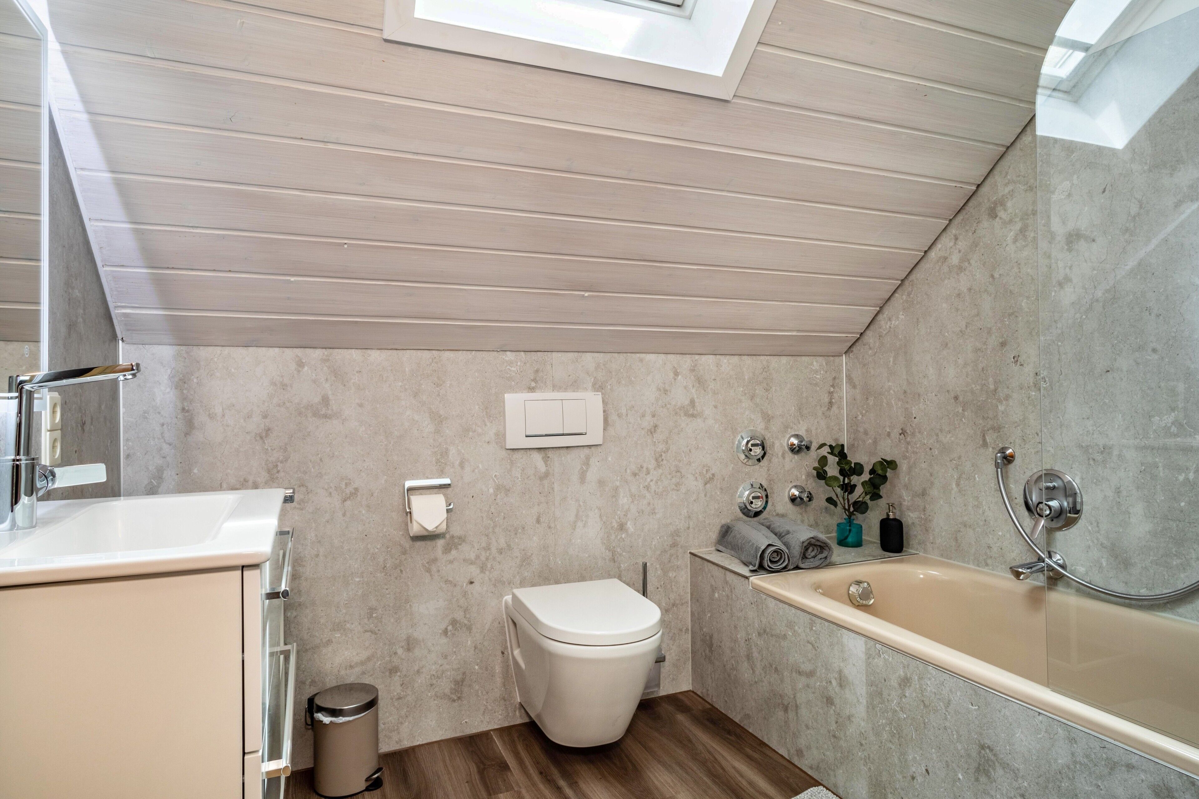 A modern bathroom with a toilet, sink, and bathtub.