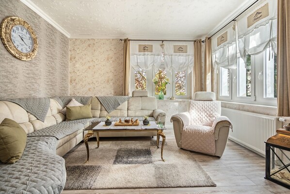 Un salon comprenant un canapé, un fauteuil, une table basse et des objets de décoration.
