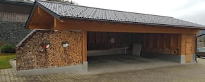 Un bâtiment doté d’un toit en pente, d’une façade en bois et d’un mur en pierre.