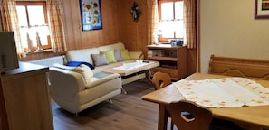 Une pièce confortable avec un canapé, une table à manger et un téléviseur.