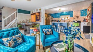 A modern kitchen with a blue backsplash, a dining area with blue upholstered chairs, and a staircase leading to an upper level. - Lake - King - Gym - Kayak - Fire Pit - PetsOK - WD (Ashford)