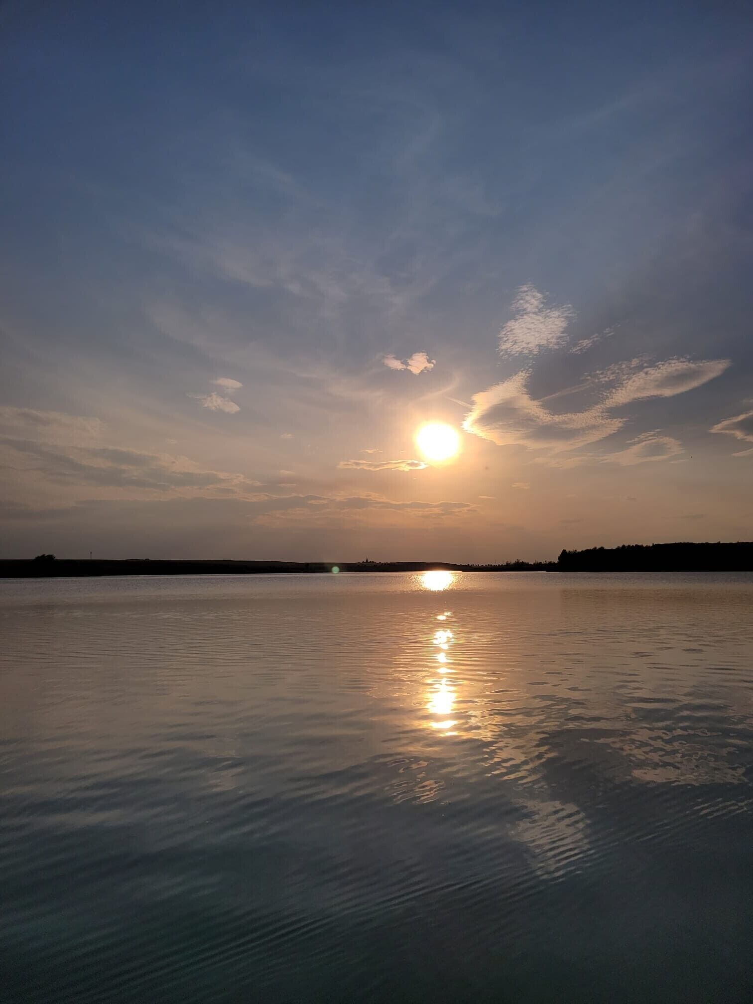 A calm body of water reflecting the sun.