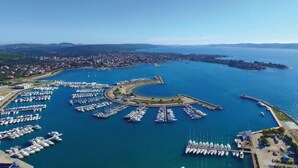 An aerial view of a marina with numerous boats docked in a circular arrangement, surrounded by a coastal town. - Nice apartment for 3 people with WIFI, A/C, TV and terrace (Zadar)