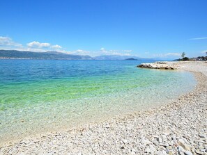 A pebble beach with clear water and distant mountains. - Lovely apartment for 5 guests with WIFI, A/C, TV and terrace (Solin)