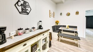 A kitchen with a coffee bar, a dining area with a bench, and a coffee machine. - Cozy Fort Walton Beach Escape w/ Private Patio! (Fort Walton Beach)