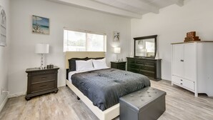 A bedroom with a bed, bedside tables, a dresser, a bench, and a wardrobe. - Cozy Fort Walton Beach Escape w/ Private Patio! (Fort Walton Beach)