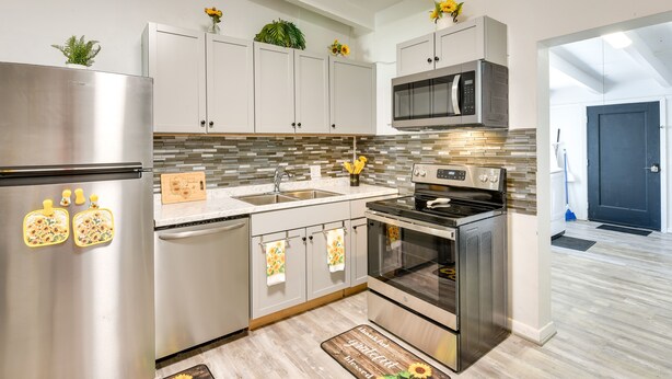 A modern kitchen with stainless steel appliances, white cabinets, and decorative plants. - Cozy Fort Walton Beach Escape w/ Private Patio! (Fort Walton Beach)