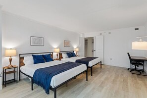 Een hotelkamer met twee eenpersoonsbedden, een bureau en een stoel.