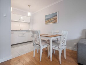 Enjoy meals in this kitchen and dining area, featuring a stainless steel sink, pendant light, and dining table with four chairs.