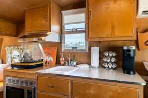 Fridge, microwave, coffee/tea maker, cookware/dishes/utensils
