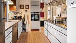 Une cuisine moderne avec un plancher en bois, des appareils en acier inoxydable et un îlot central.
