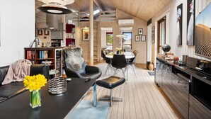 Un intérieur moderne avec un plafond en bois, un coin repas et un espace de vie comprenant un canapé et une table basse.