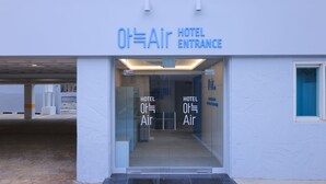 L'entrée d'un hôtel de type « Air Hotel », avec des portes en verre et une enseigne au-dessus.