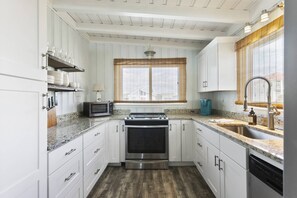Enjoy cooking in this kitchen with a stainless steel range, oven, and microwave, plus a sink and window with neighborhood views.