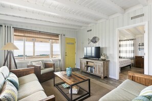 Relax in this inviting living room with a sofa, armchairs, and TV.