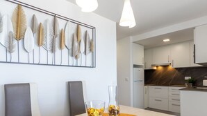 A modern kitchen with white cabinets, a marble backsplash, and a built-in oven. - Cosy apartment for 5 guests with A/C, WIFI, TV and balcony (Salou)