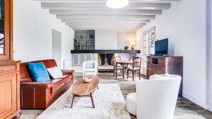 Ein geräumiges Wohnzimmer mit Kamin, Essbereich und Fernseher.