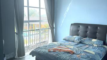 A bedroom with a large bed, a window with curtains, and a view of the outside.