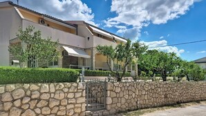 A two-story building with a stone wall and a gated entrance. - Lovely apartment for 4 people with WIFI, A/C, TV and terrace (Zadar)