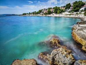 A coastal town with clear turquoise waters, rocky shorelines, and buildings on the hillside. - Cosy apartment for 4 people with A/C, WIFI, TV and terrace (Solin)