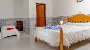 Un dormitorio con una cama de madera, una mesita de noche, un aparador y una puerta.