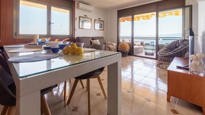 Un salon moderne avec une table à manger en verre, un canapé et un balcon offrant une vue agréable.