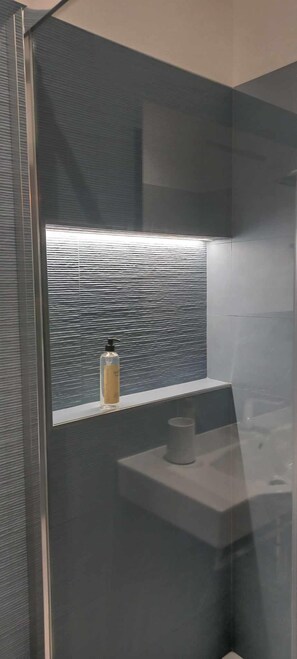 Familie vierpersoonskamer | Badkamer | Een douche, een regendouche, een haardroger, een bidet