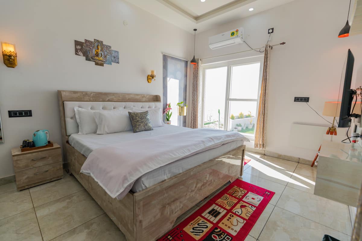 Un dormitorio moderno con una cama grande, mesitas de noche, una alfombra roja y vistas al exterior.