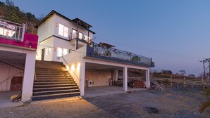 Une maison à deux étages dotée d’un balcon, d’un escalier menant à l’étage supérieur et d’une allée.