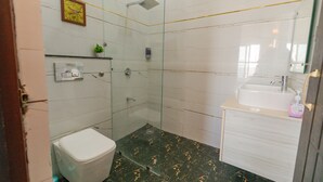 Une salle de bain avec des toilettes, une douche et un lavabo.