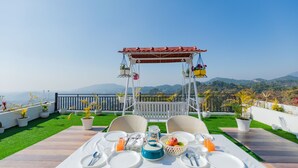 Une table dressée pour le petit-déjeuner, avec vue sur les montagnes.