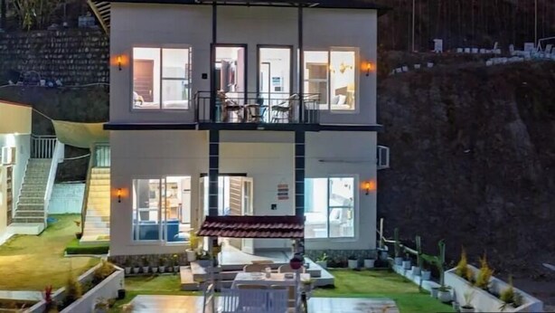 Un bâtiment à deux étages, doté de nombreuses fenêtres, d’un balcon et d’un intérieur bien éclairé.