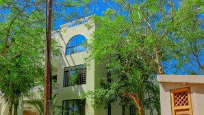 A two-story building with arched windows and a balcony. - Silent Palms Villa
 (diani)