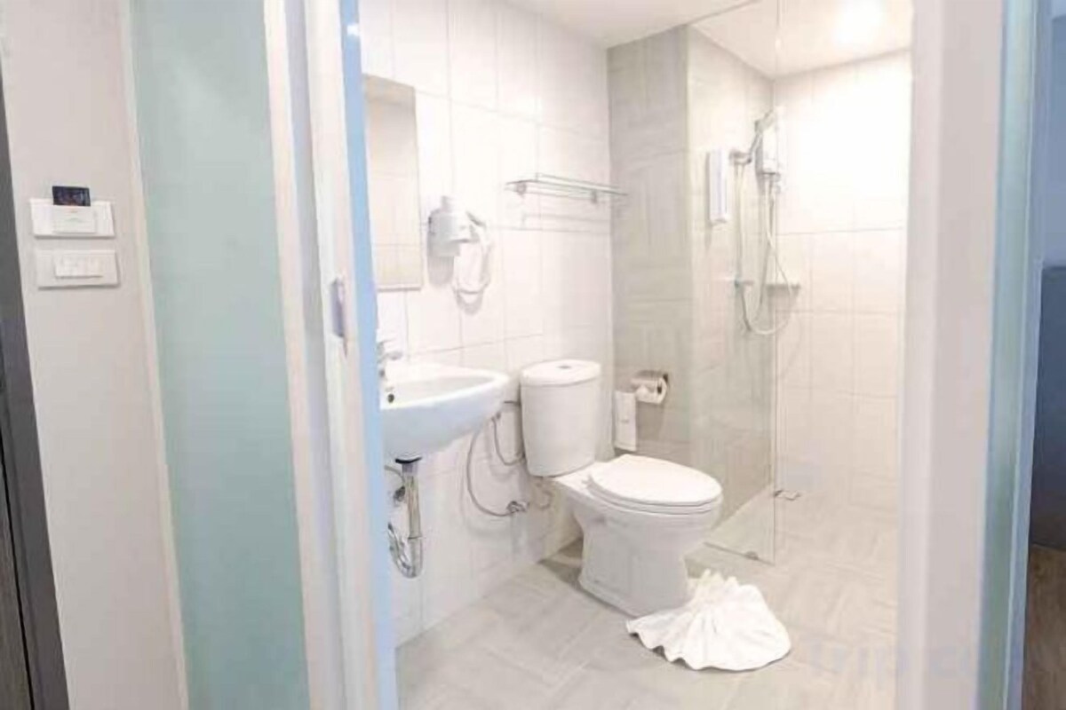 Un baño con inodoro, lavamanos y ducha.