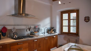 A kitchen with wooden cabinets, a stainless steel range hood, a sink, and a window with a view of the outside. - Mansion in Pescaglia near Tuscan Coast (Pascoso - Pescaglia (LUCCA))