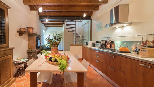 A modern kitchen with wooden cabinets, a marble countertop, and a central island with fresh produce. - Mansion in Pescaglia near Tuscan Coast (Pascoso - Pescaglia (LUCCA))
