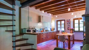 A modern kitchen with wooden cabinets, a built-in oven, and a dining area with a table and chairs. - Mansion in Pescaglia near Tuscan Coast (Pascoso - Pescaglia (LUCCA))