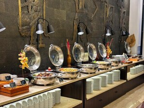 A buffet with various food items and a decorative wall. - The Malioboro Hotel & Conference Center (Yogyakarta)