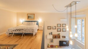 Un dormitorio moderno con cama, mesita de noche, televisor y escritorio con silla.