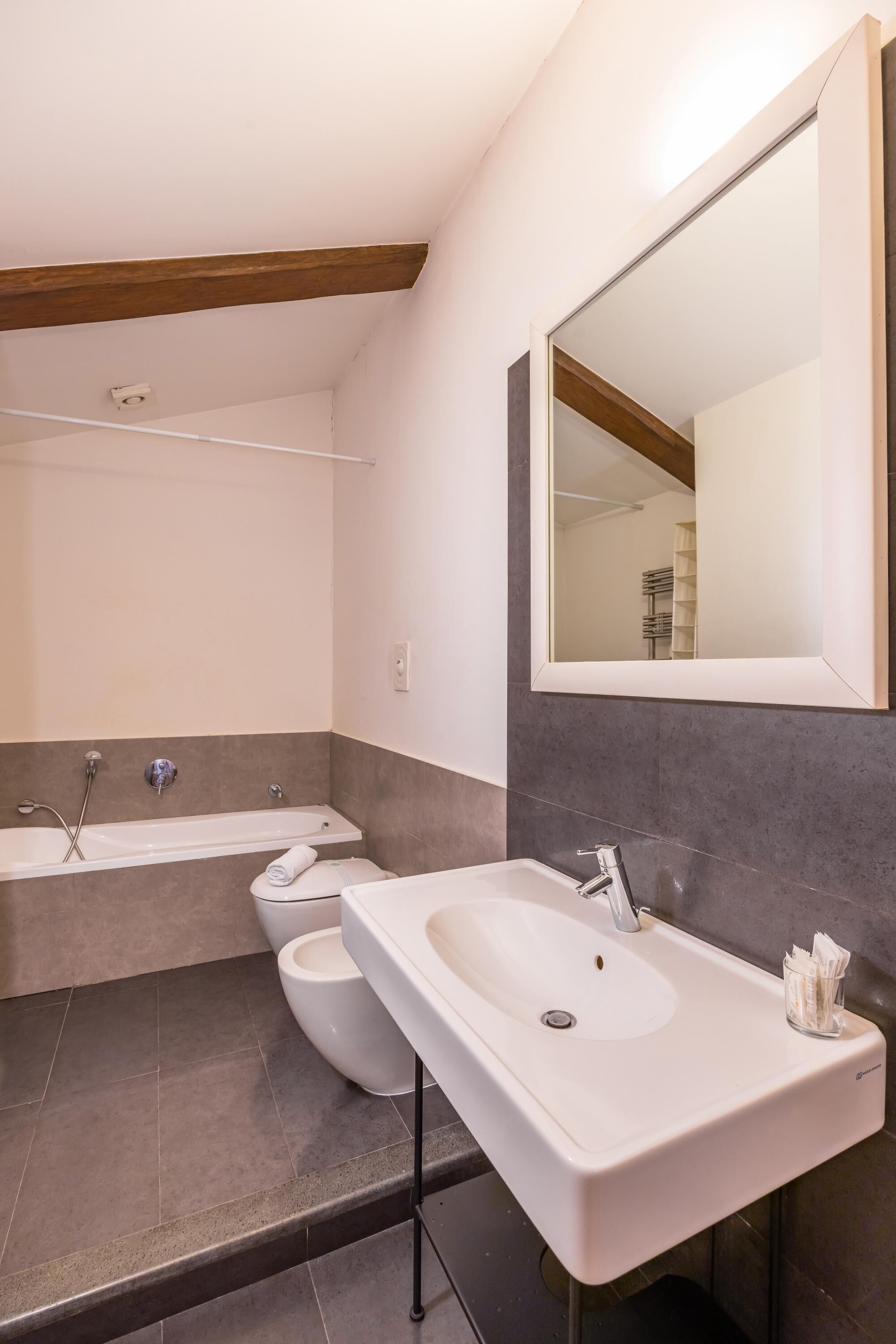 A modern bathroom with a bathtub, a sink, and a toilet.