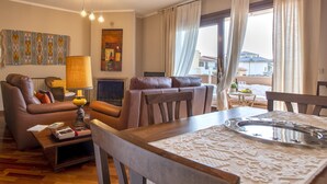 Een woonkamer met een bank, een eettafel met dienblad en een lamp.