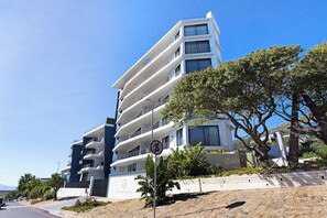 Un hôtel à plusieurs étages doté de balcons, un ciel dégagé et un panneau indiquant une zone où le stationnement est interdit.