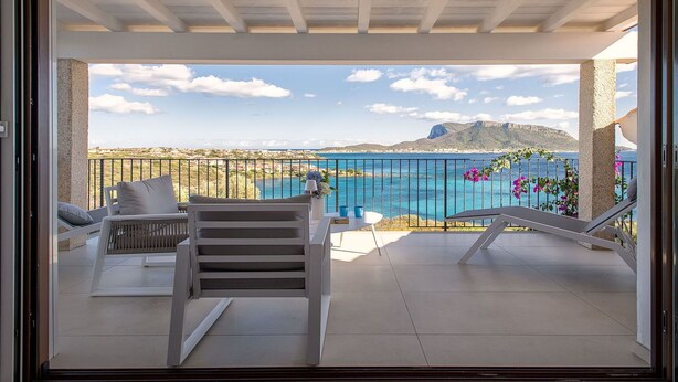 A balcony with a view of the sea and a mountain, featuring a white chair and a small table. - Nice apartment for 5 guests with A/C, WIFI, TV and terrace (Regia Dogana)